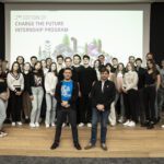 A group of students stand in the auditorium, in front of them LG Energy Solution's HR Director and AI Manager
